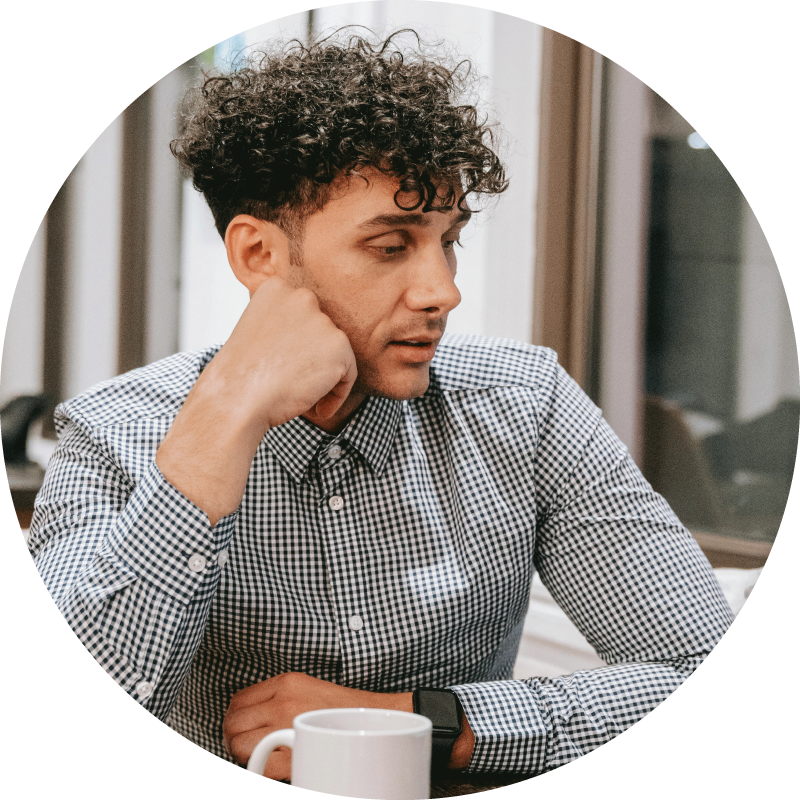 anxious man with coffee mug, looking down